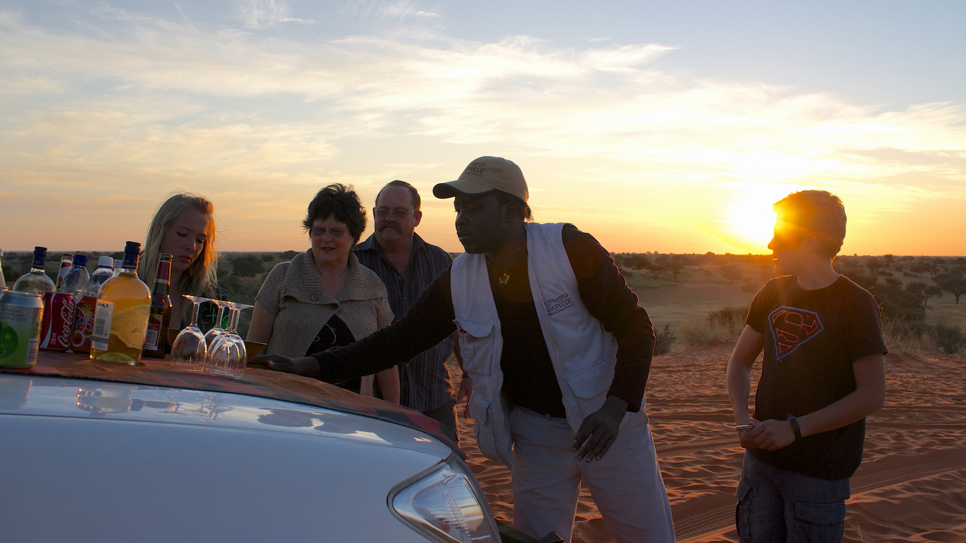 Guests enjoying a sundowner on a red dune at Bagatelle