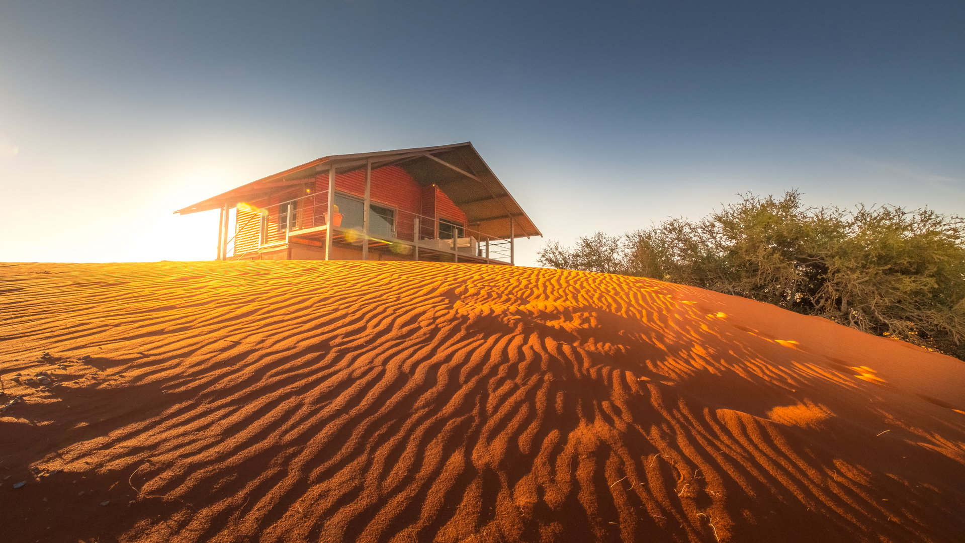 A Bagatelle dune chalet on stilts above the red Kalahari dunes at sunset