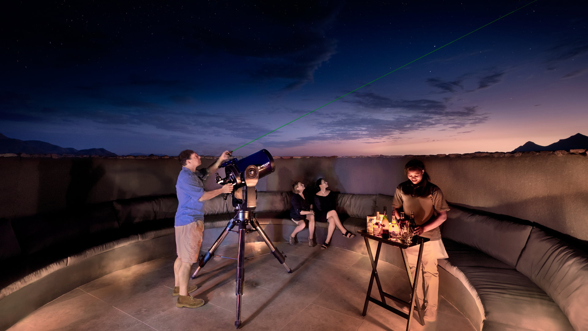 Guests at the telescope under the night sky at andBeyond Sossusvlei Desert Lodge