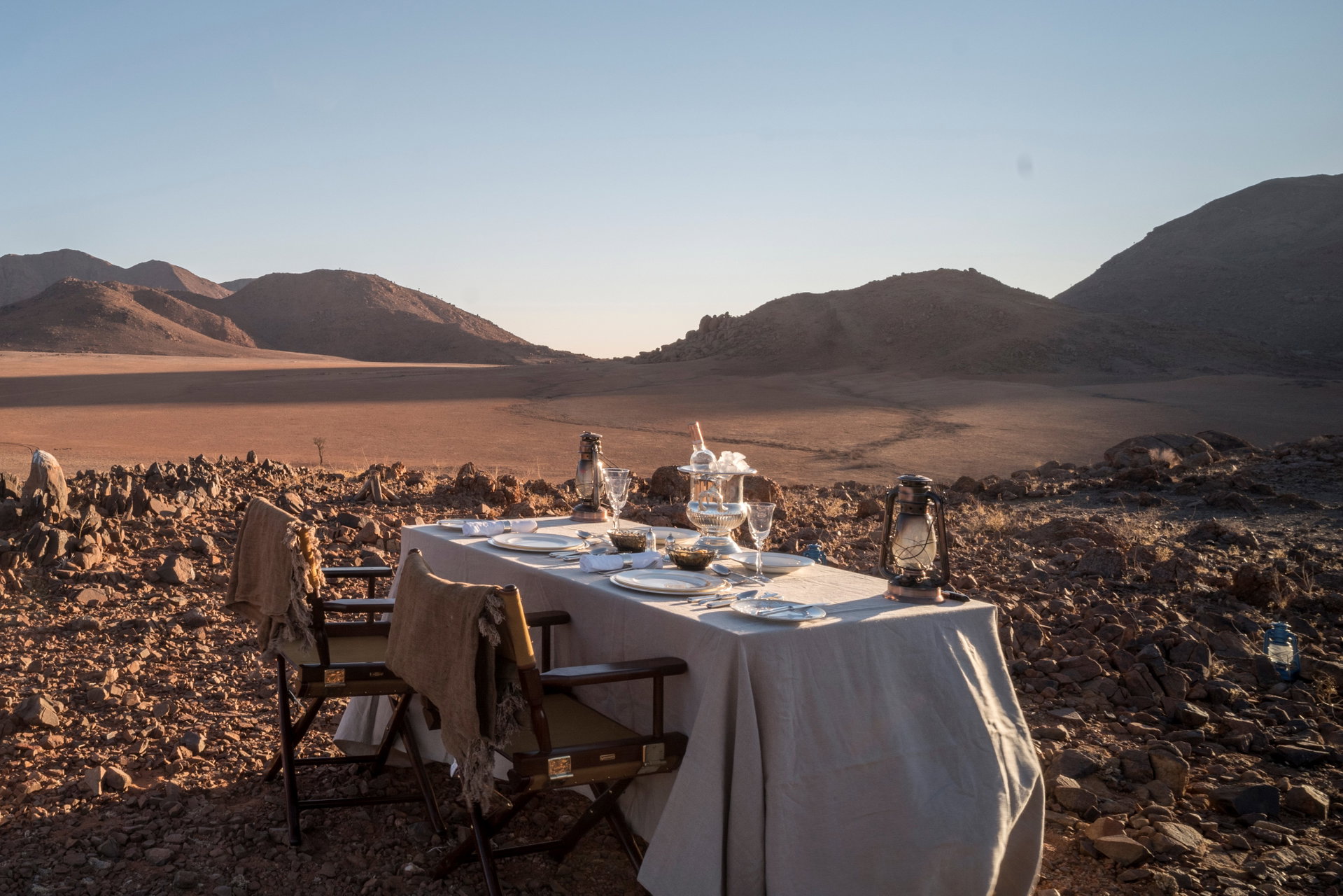 A dinner table laid out in the desert at Zannier Sonop