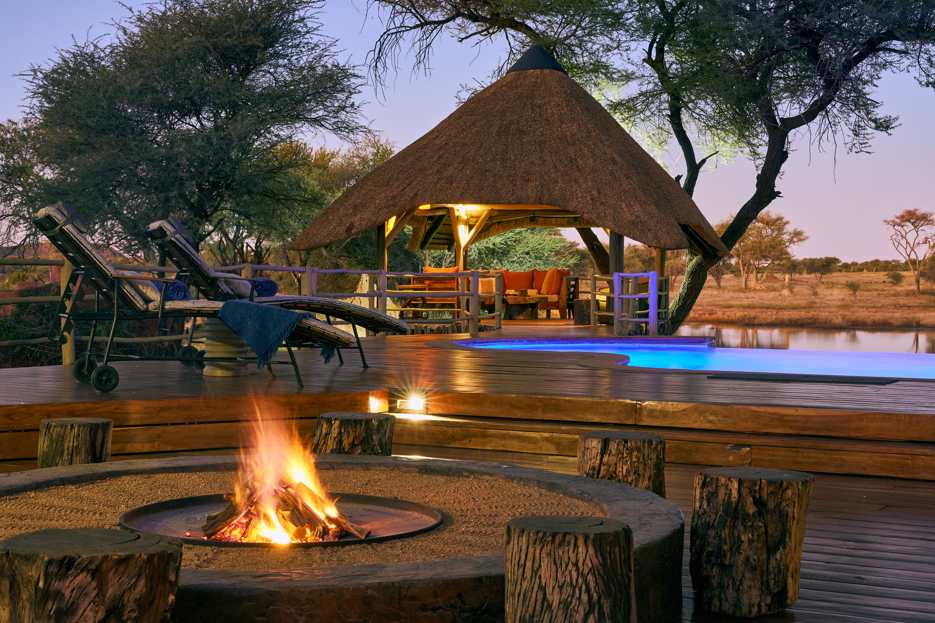 The fire pit and deck of Okonjima African Villa at dusk