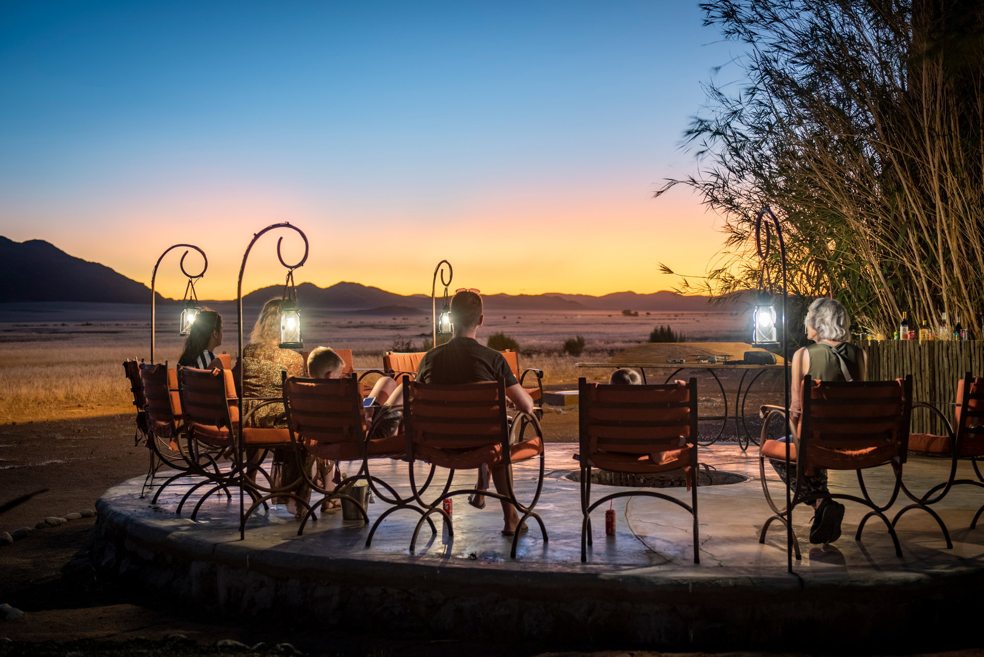 Guests around the fire pit at sunset at Le Mirage