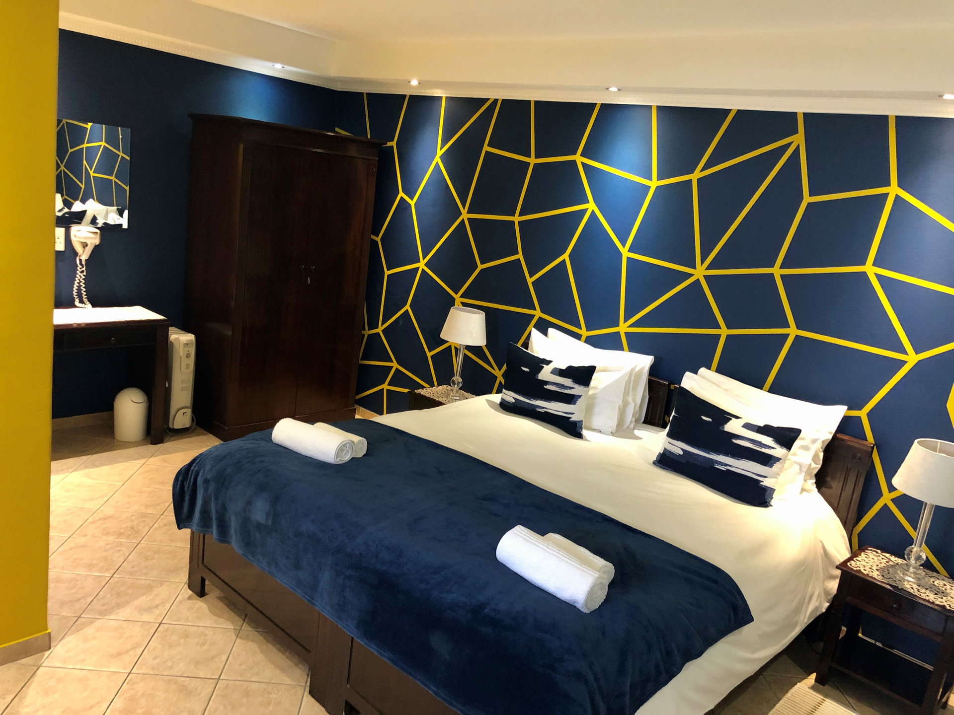 A bedroom with a deep blue wall at Sea Breeze Guesthouse