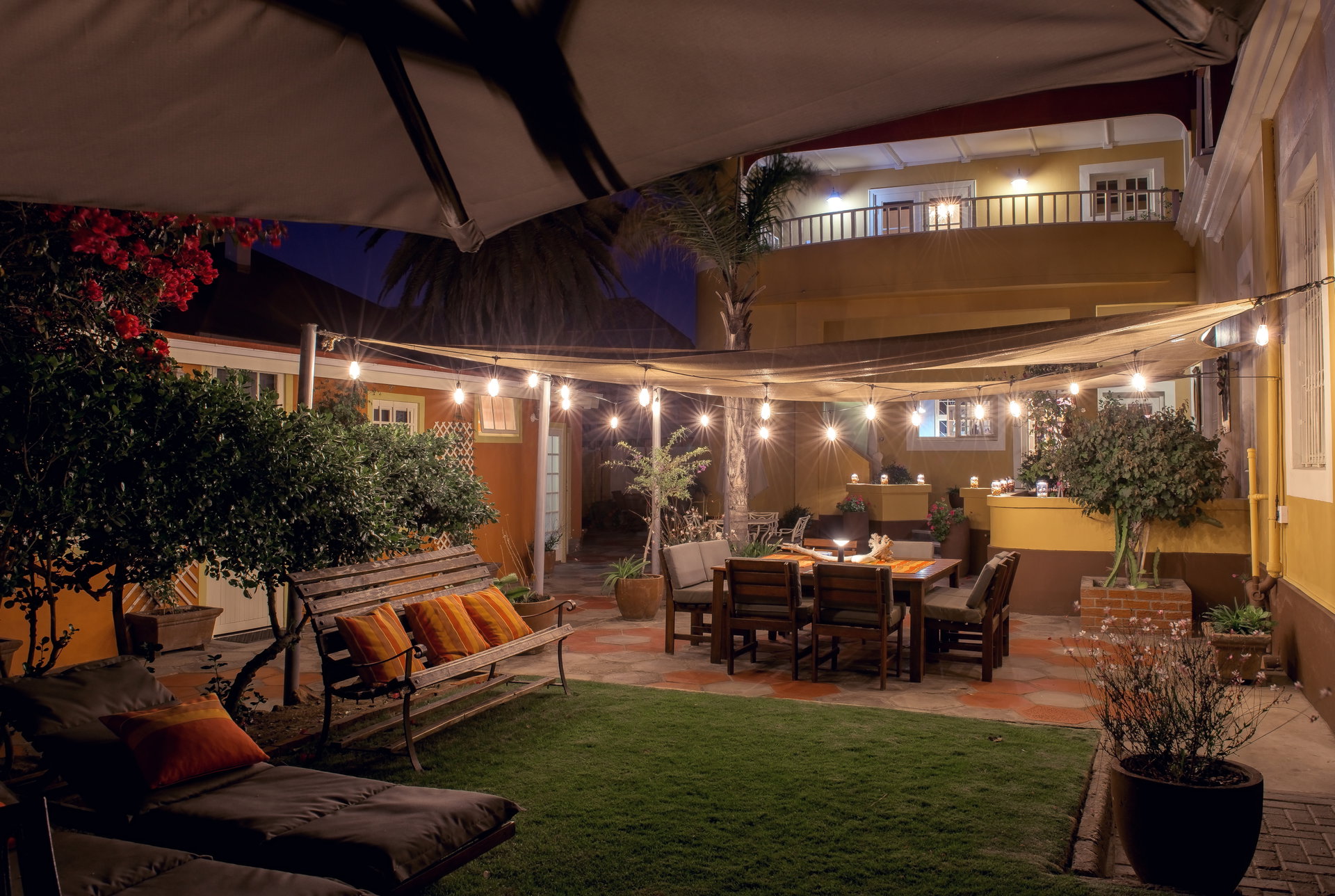 The garden courtyard at Villa Margherita lit with string lights in the evening